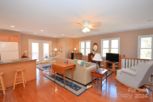 living room with ceiling fan, light hardwood / wood-style floors, and french doors