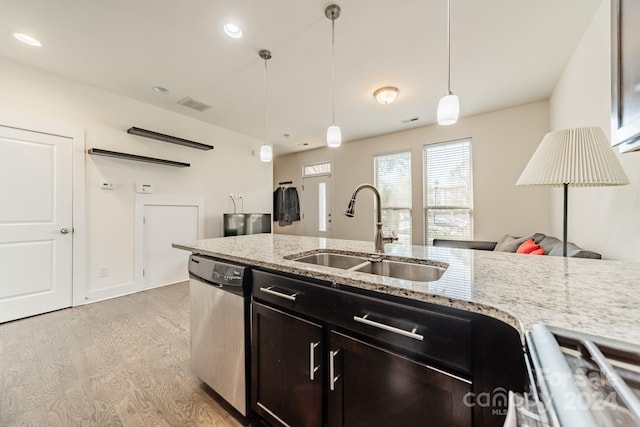 kitchen featuring pendant lighting, dishwasher, sink, light stone countertops, and light hardwood / wood-style floors