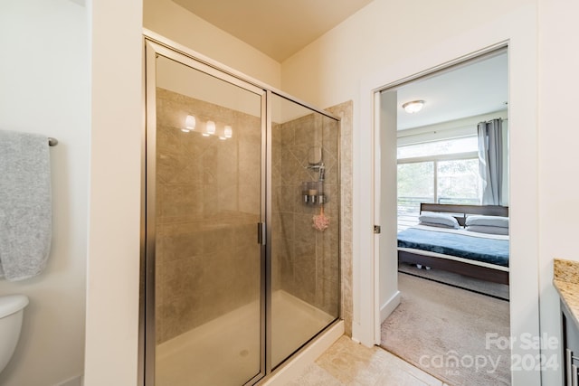 bathroom with tile patterned floors, a shower with shower door, and toilet