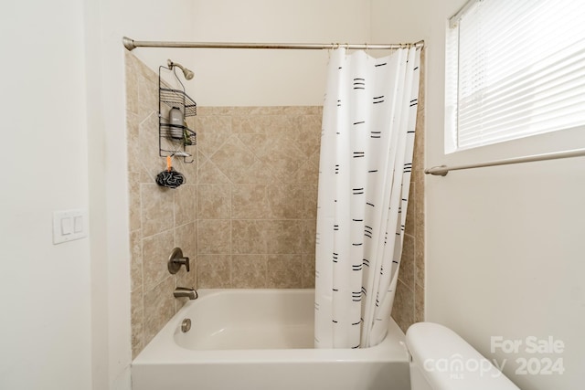 bathroom with shower / bath combo with shower curtain and toilet