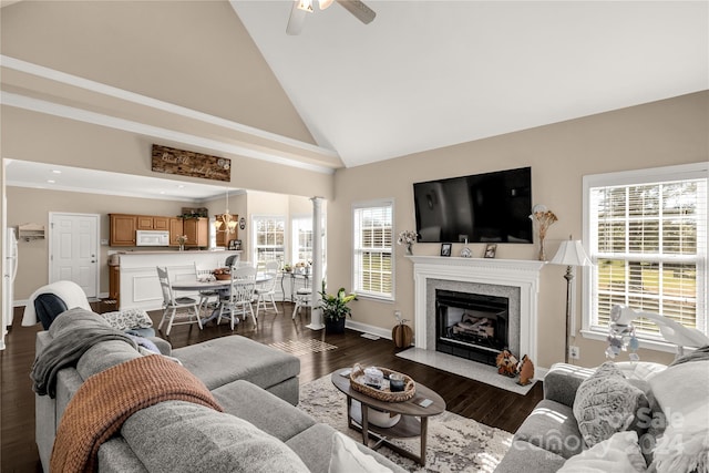 living room with dark hardwood / wood-style flooring, decorative columns, high vaulted ceiling, and ceiling fan