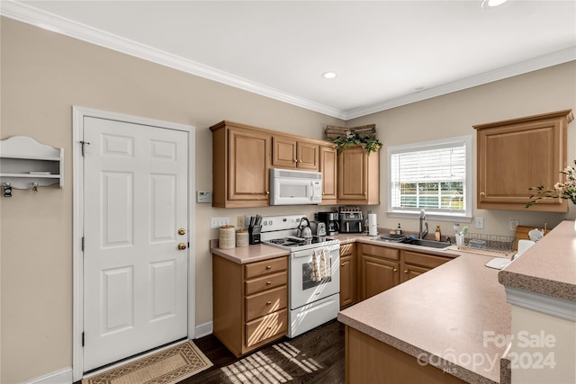 kitchen featuring kitchen peninsula, dark hardwood / wood-style flooring, ornamental molding, white appliances, and sink