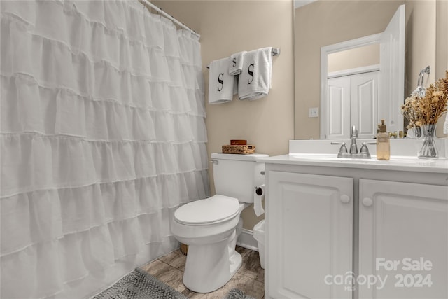 bathroom featuring toilet, tile patterned flooring, vanity, and a shower with shower curtain