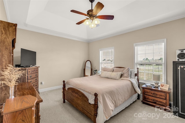 carpeted bedroom featuring a tray ceiling, ceiling fan, and ornamental molding