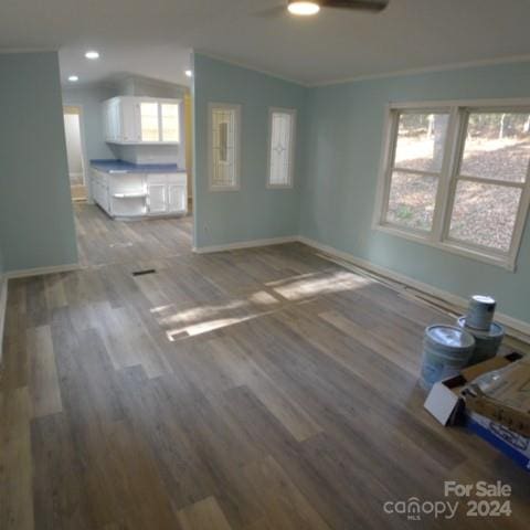 unfurnished living room with wood-type flooring, a wealth of natural light, lofted ceiling, and ceiling fan