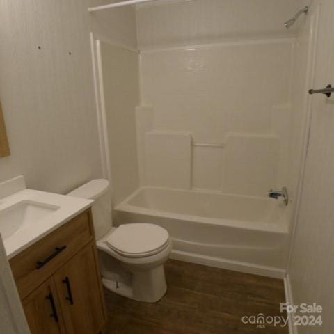 full bathroom with washtub / shower combination, vanity, hardwood / wood-style flooring, and toilet