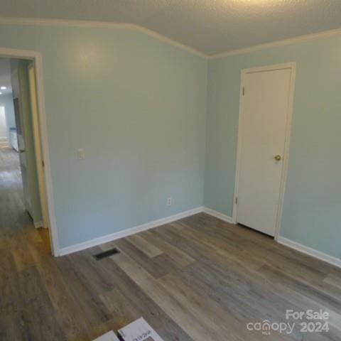 spare room with wood-type flooring and crown molding