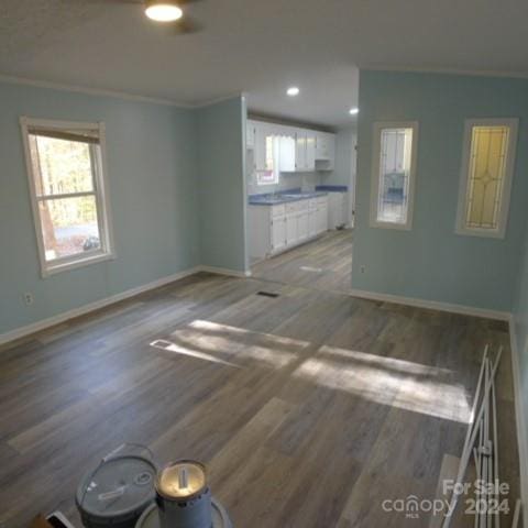 unfurnished living room with crown molding and hardwood / wood-style flooring