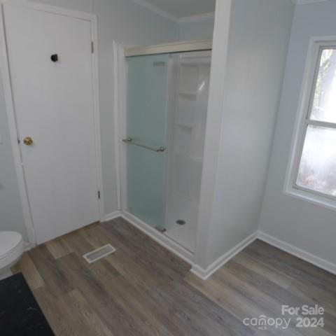 bathroom featuring toilet, a healthy amount of sunlight, an enclosed shower, and wood-type flooring