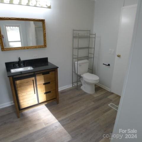 bathroom featuring hardwood / wood-style floors, vanity, and toilet