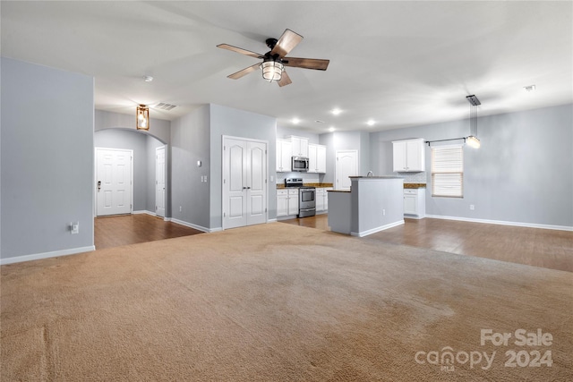 unfurnished living room featuring hardwood / wood-style floors and ceiling fan