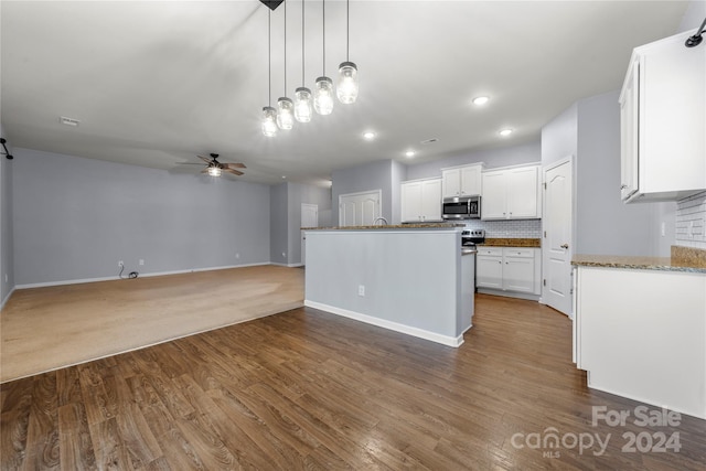 kitchen featuring white cabinetry, ceiling fan, tasteful backsplash, dark hardwood / wood-style flooring, and pendant lighting