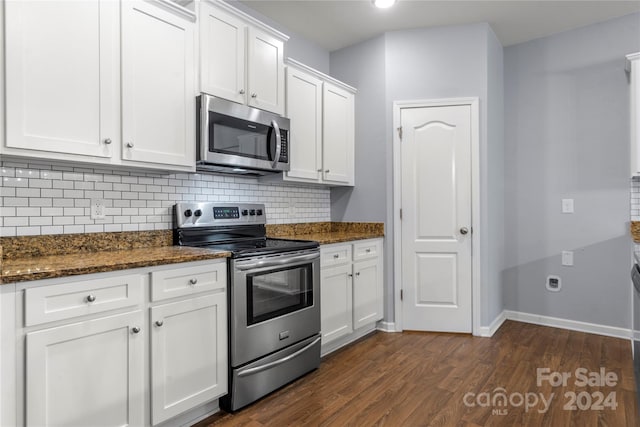 kitchen featuring decorative backsplash, appliances with stainless steel finishes, dark stone counters, dark hardwood / wood-style floors, and white cabinetry