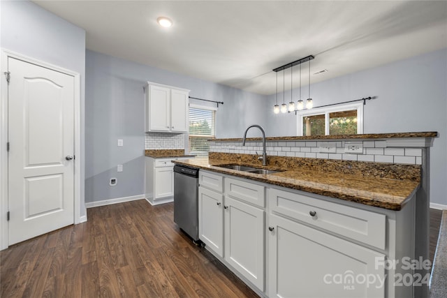 kitchen featuring white cabinets, sink, hanging light fixtures, stainless steel dishwasher, and a wealth of natural light