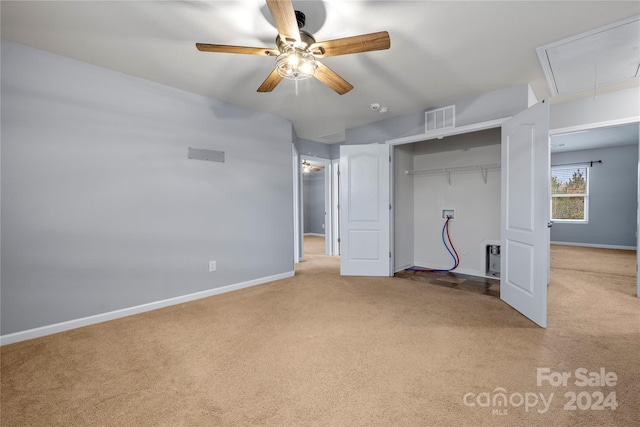 unfurnished bedroom with ceiling fan, a closet, and light colored carpet