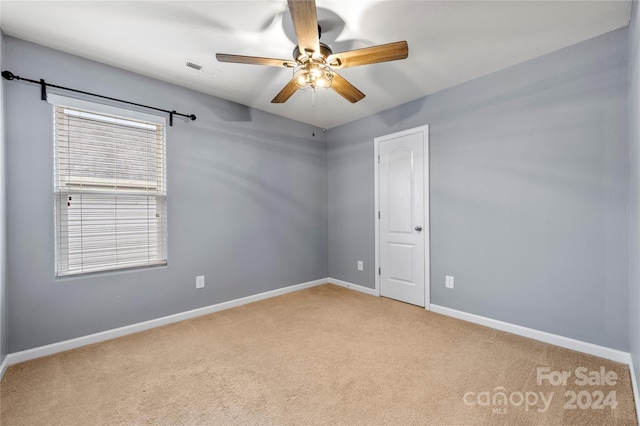 spare room featuring ceiling fan and light colored carpet