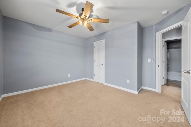 unfurnished bedroom featuring ceiling fan, light carpet, and a closet