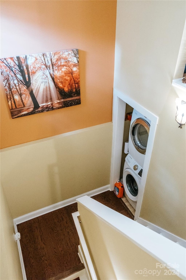 laundry room featuring hardwood / wood-style floors and stacked washer and clothes dryer