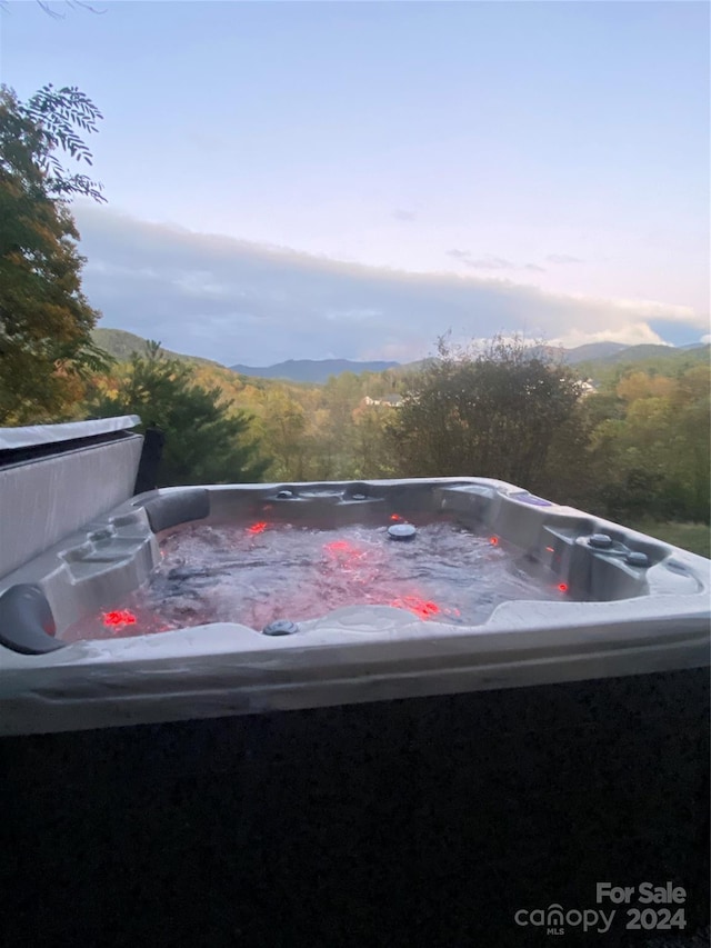 exterior space featuring a mountain view and a hot tub