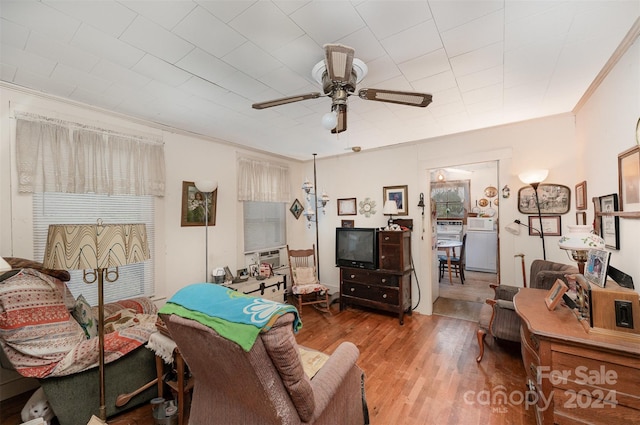 living room featuring hardwood / wood-style flooring, ceiling fan, and ornamental molding