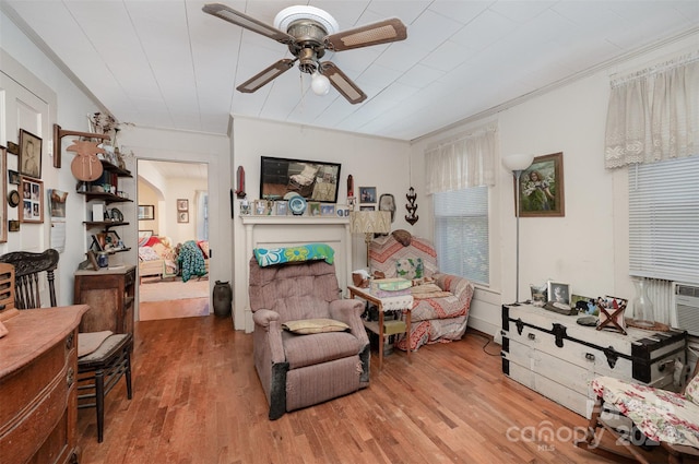 living room with hardwood / wood-style floors, ceiling fan, and crown molding