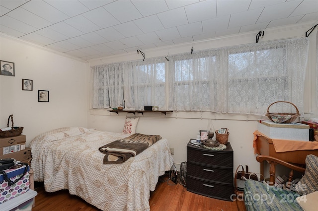 bedroom featuring wood-type flooring and crown molding