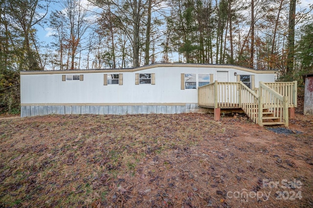 rear view of house featuring a wooden deck