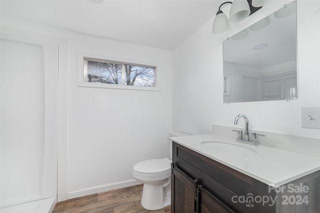 bathroom featuring wood-type flooring, vanity, and toilet