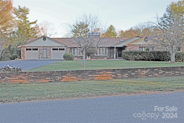 ranch-style house featuring a front yard and a garage