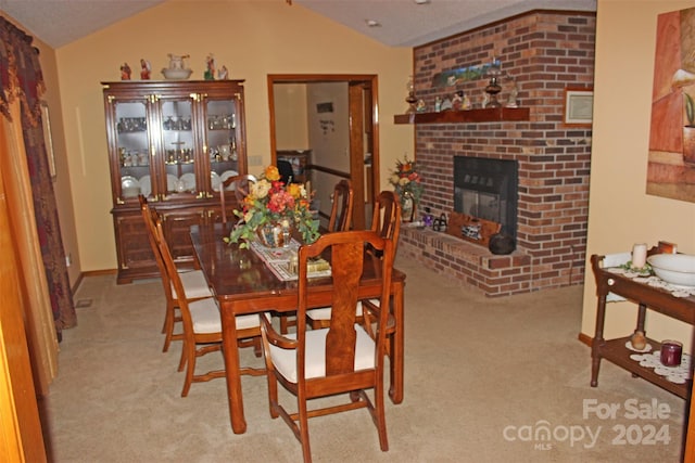 carpeted dining space with a fireplace and lofted ceiling