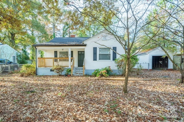 view of front of property with covered porch, an outdoor structure, and a garage