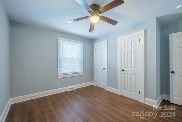 unfurnished bedroom featuring ceiling fan and dark hardwood / wood-style flooring