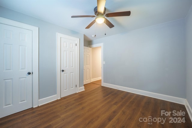 unfurnished bedroom featuring ceiling fan and dark hardwood / wood-style floors