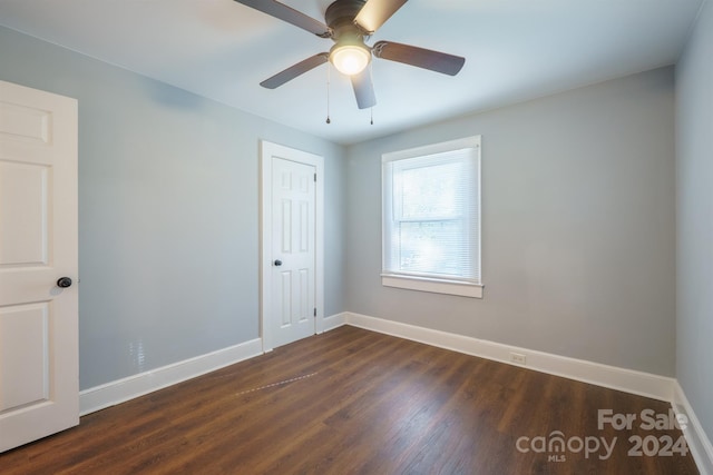 empty room with ceiling fan and dark wood-type flooring