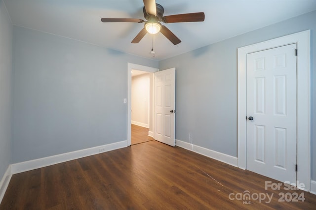 unfurnished bedroom with ceiling fan and dark hardwood / wood-style flooring