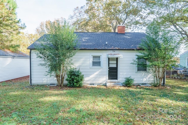 rear view of house featuring a lawn