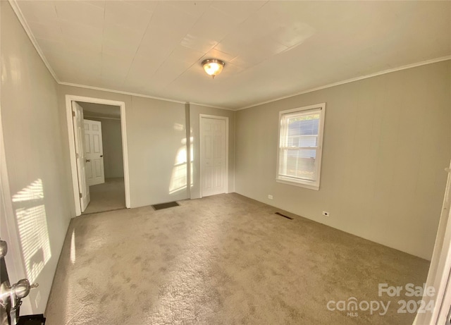 carpeted spare room with crown molding