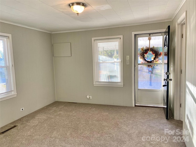 foyer with light carpet and ornamental molding