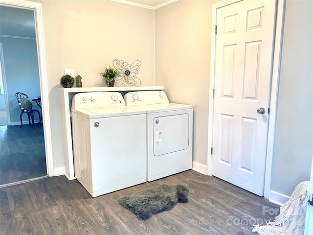 laundry area featuring washer and clothes dryer, dark wood-type flooring, and ornamental molding