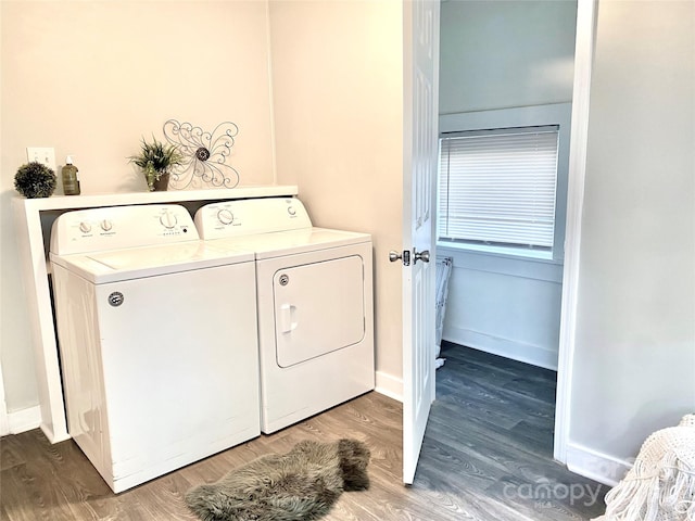 laundry room featuring washing machine and clothes dryer and hardwood / wood-style floors