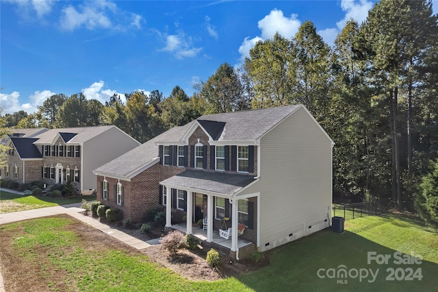 view of front of property with a porch, central AC unit, and a front lawn