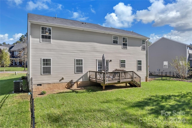 rear view of property featuring a lawn, cooling unit, and a wooden deck