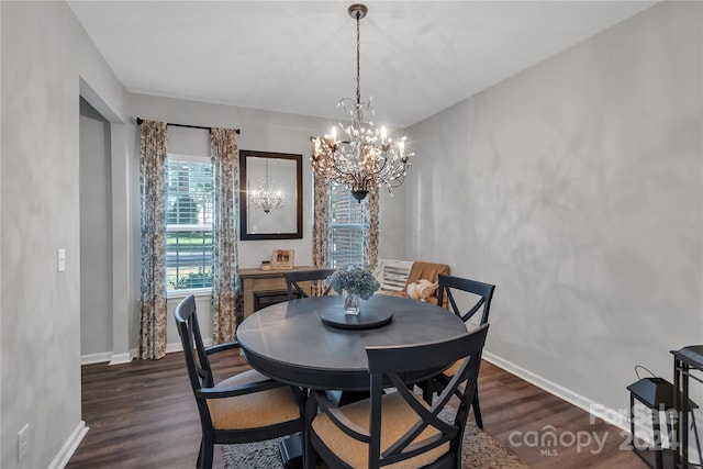 dining area featuring dark hardwood / wood-style flooring and an inviting chandelier