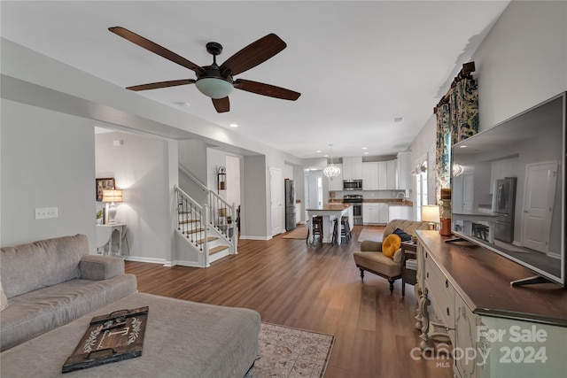 living room featuring hardwood / wood-style floors, ceiling fan, and sink