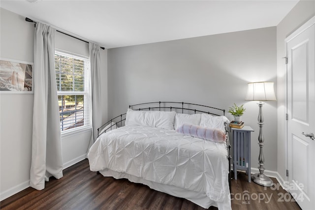 bedroom with dark hardwood / wood-style flooring