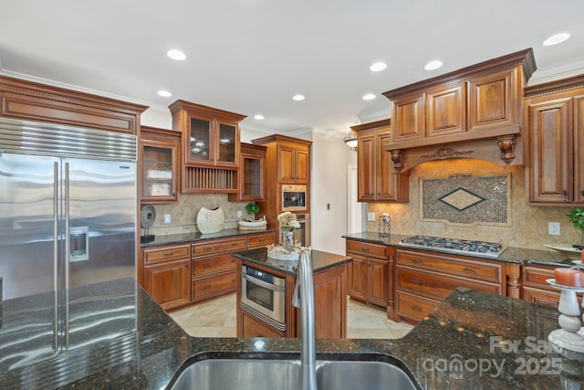 kitchen with sink, decorative backsplash, dark stone countertops, light tile patterned floors, and stainless steel appliances