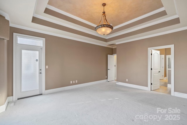 carpeted spare room with a tray ceiling and crown molding