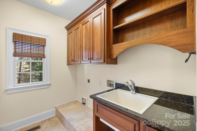 laundry area with hookup for an electric dryer, hookup for a washing machine, cabinets, sink, and light tile patterned flooring