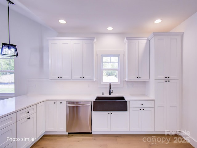 kitchen with pendant lighting, dishwasher, white cabinets, sink, and a wealth of natural light