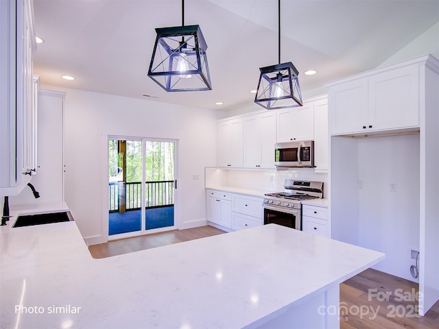 kitchen with white cabinetry, sink, hanging light fixtures, and appliances with stainless steel finishes